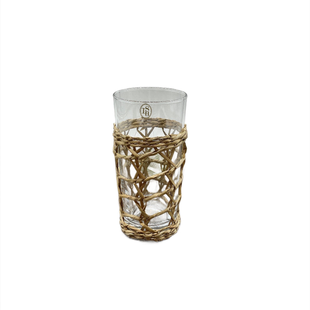 A clear highball glass with a natural woven seagrass wrapping.