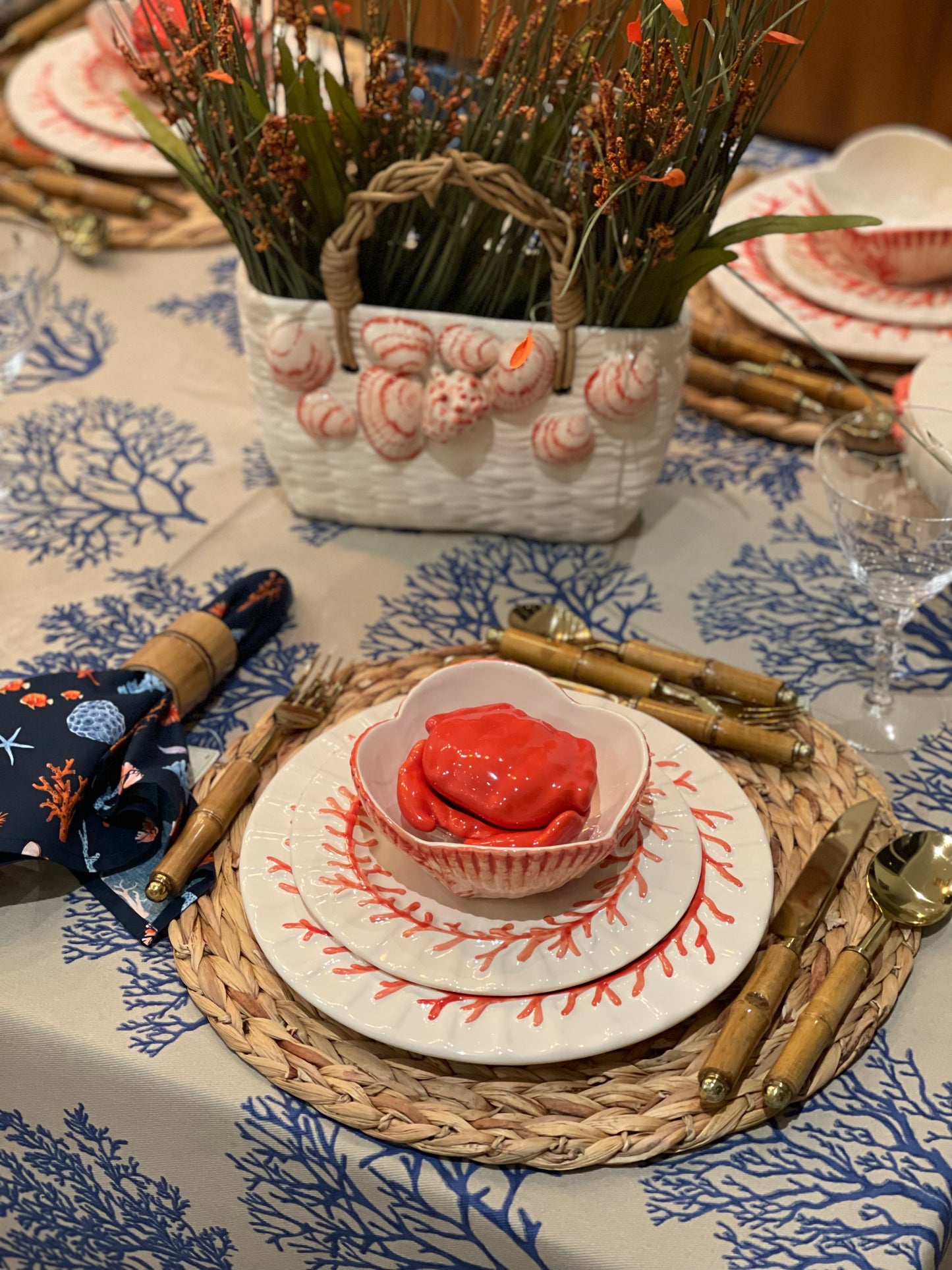 Decorative table setting with seashell-themed decor and a bowl of red food.