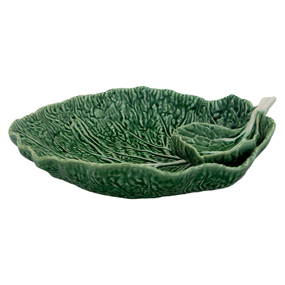A large, earthenware bowl in the shape of a cabbage leaf, primarily in green color.