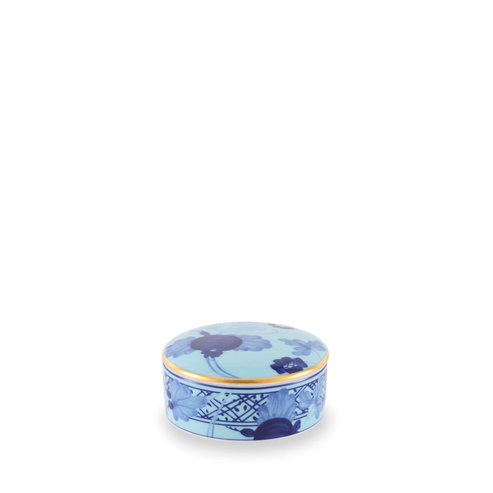 A round, blue porcelain jewelry box with gold trim and floral decorations, from the Oriente Italiano Collection.