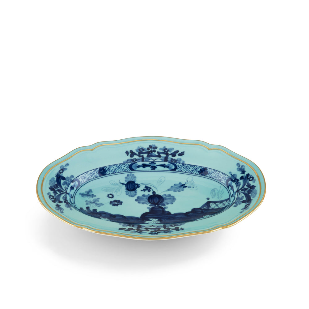 An oval-shaped porcelain pickle dish with blue floral patterns and gold threading.