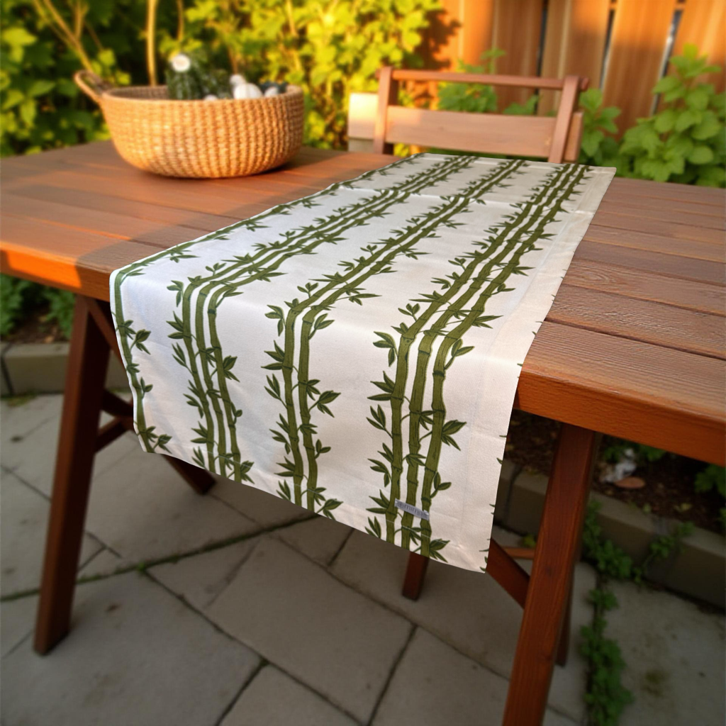 Table runner with green bamboo pattern on a wooden table outdoors