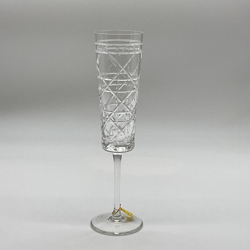 A single crystal champagne flute with a geometric pattern.
