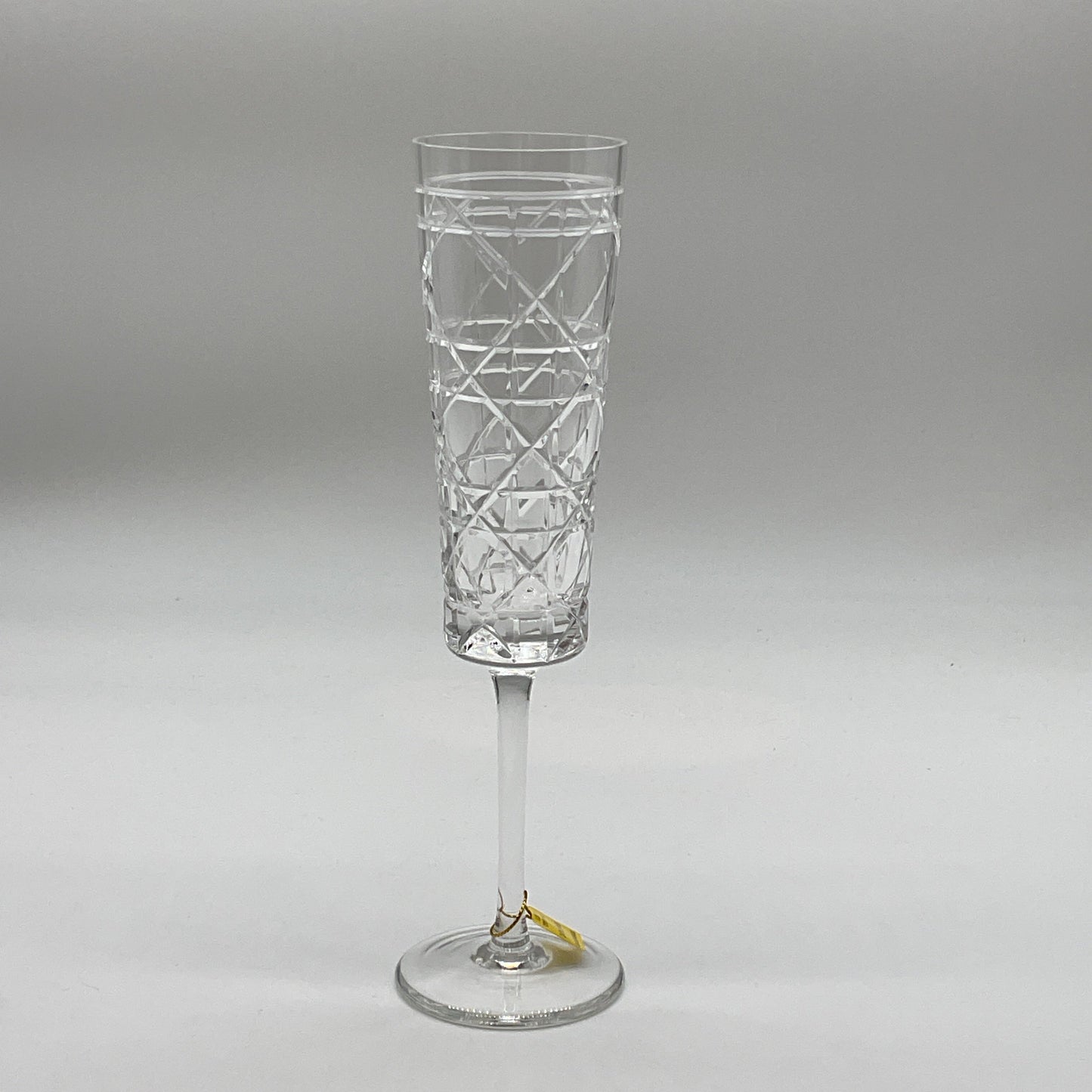 A single crystal champagne flute with a geometric pattern.