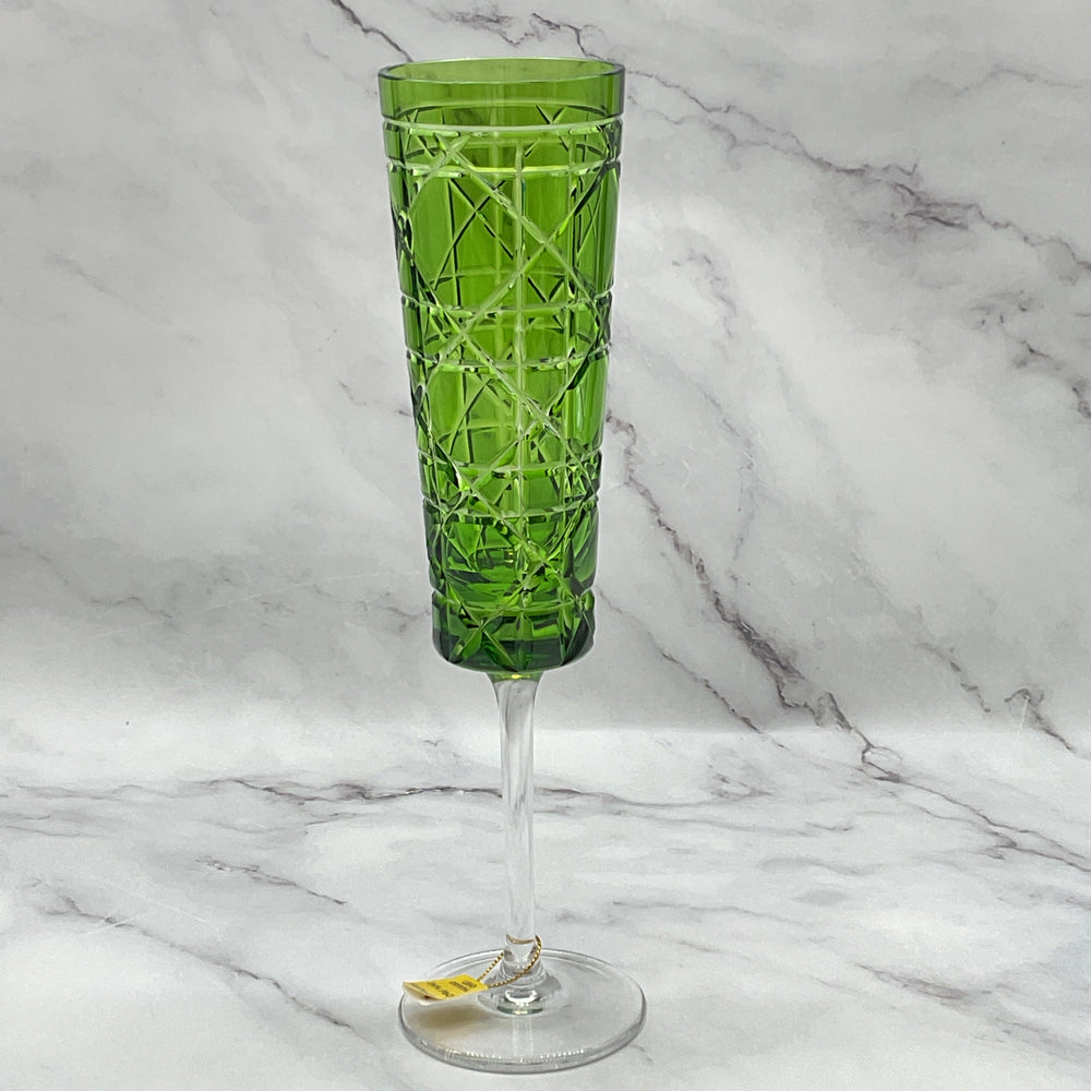 A green engraved royal crystal champagne glass with a geometric pattern.