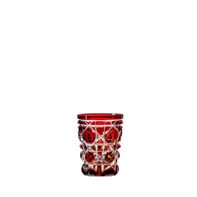 A red engraved crystal shot glass with a geometric pattern.