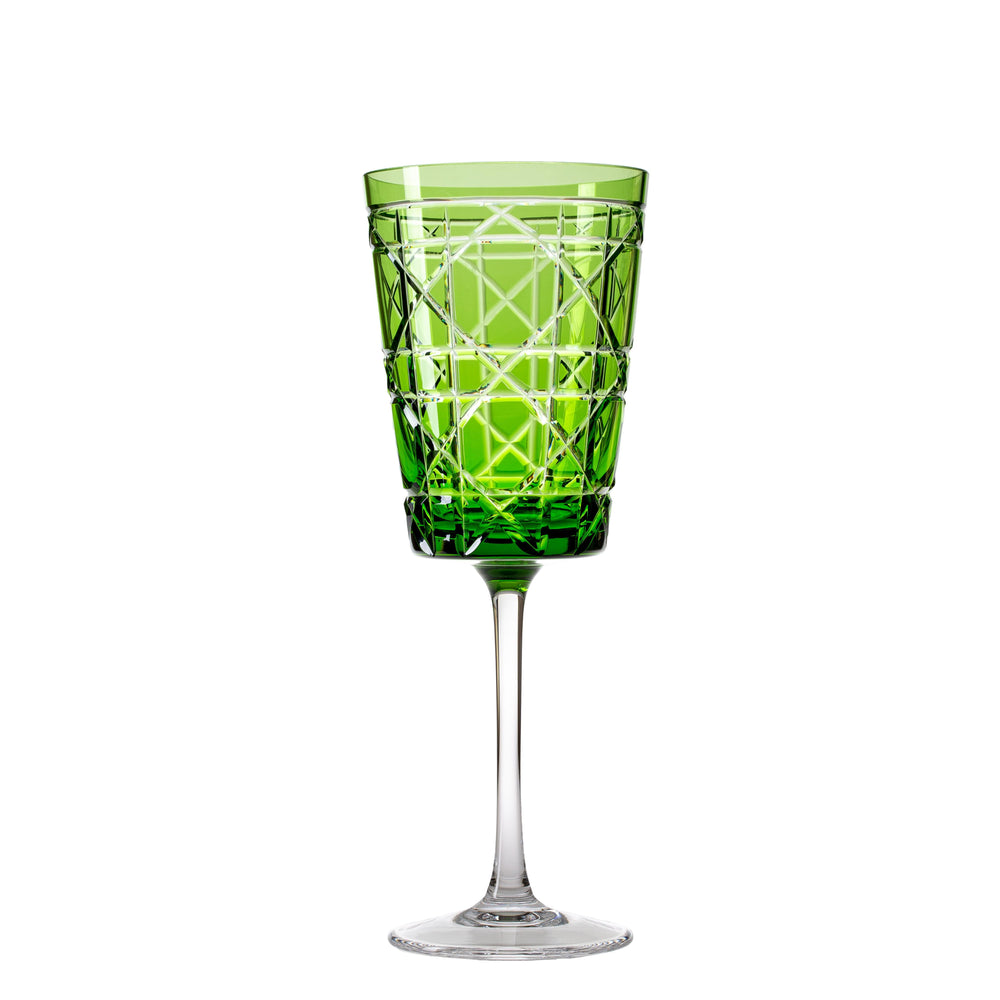 A green crystal water glass with geometric engravings on the body, with a clear glass stem and base.