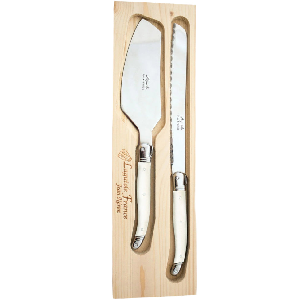 A stainless steel bread knife and cake server set with ivory handles, placed in a wooden tray with a fitted acrylic lid.