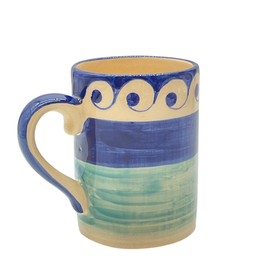 A ceramic mug with blue and green colors and bold circular accents along with a wave border.