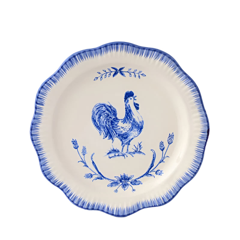 A blue and white ceramic dinner plate with a floral border and a central rooster design.