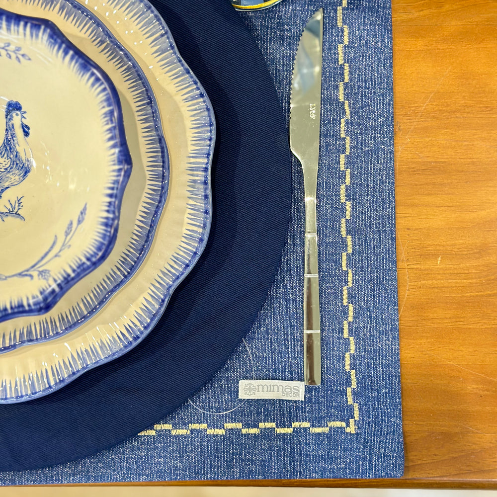 
                      
                        Navy blue and white ceramic plates with a silver knife on a blue placemat.
                      
                    