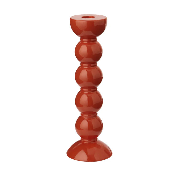 A tall orange lacquered bobbin-shaped candlestick with a sleek finish.