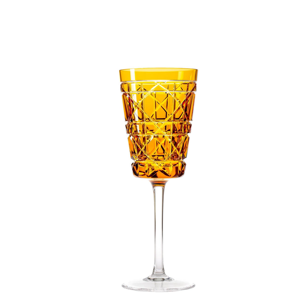 An engraved royal crystal water glass with an amber color body and a clear stem.