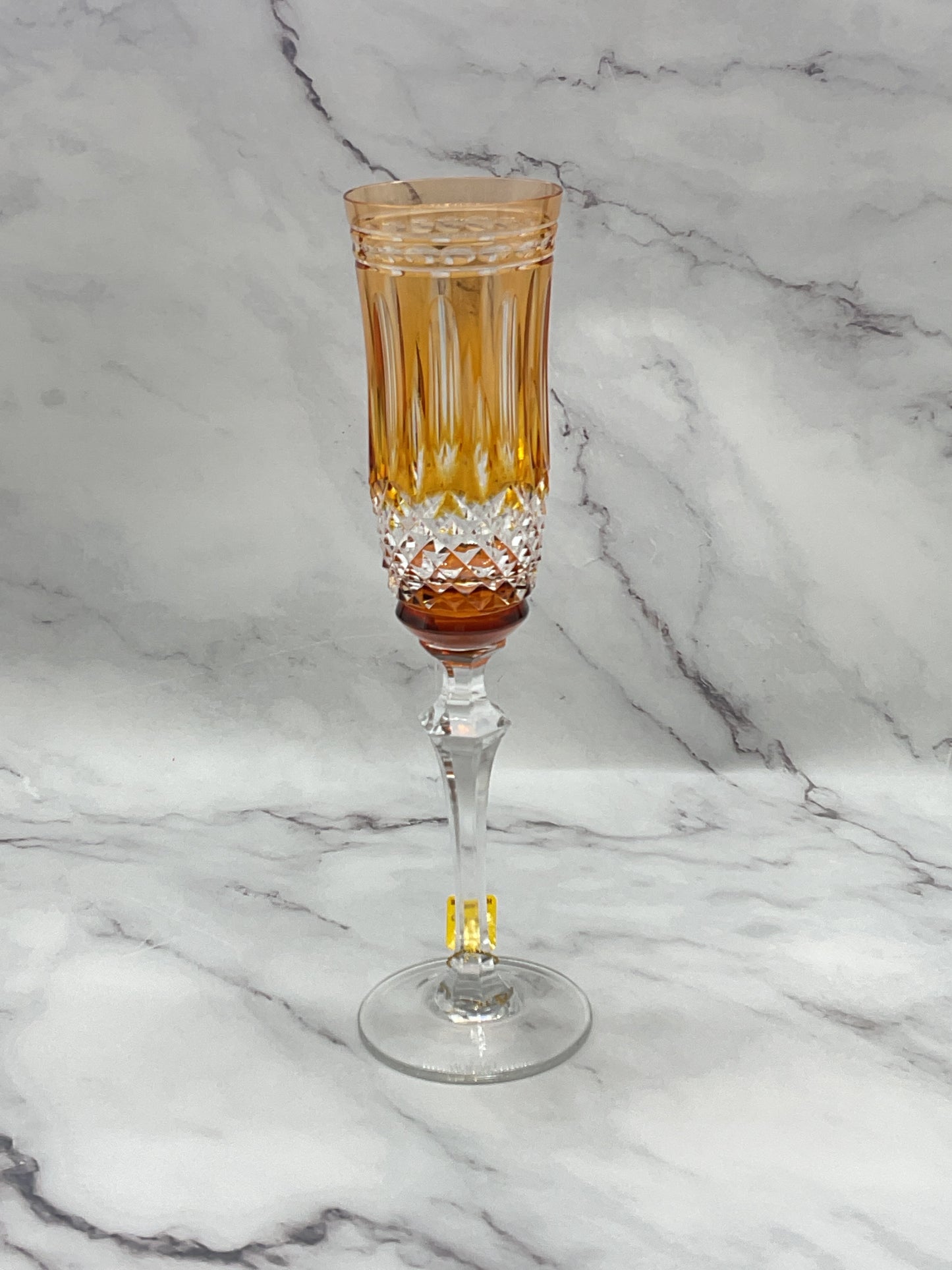 A crystal champagne glass with amber color overlay.