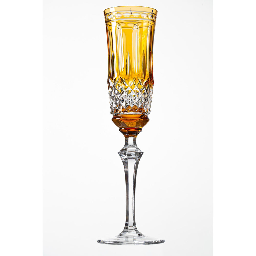 A crystal champagne glass with an amber-colored overlay on the upper part, with clear crystal design patterns.