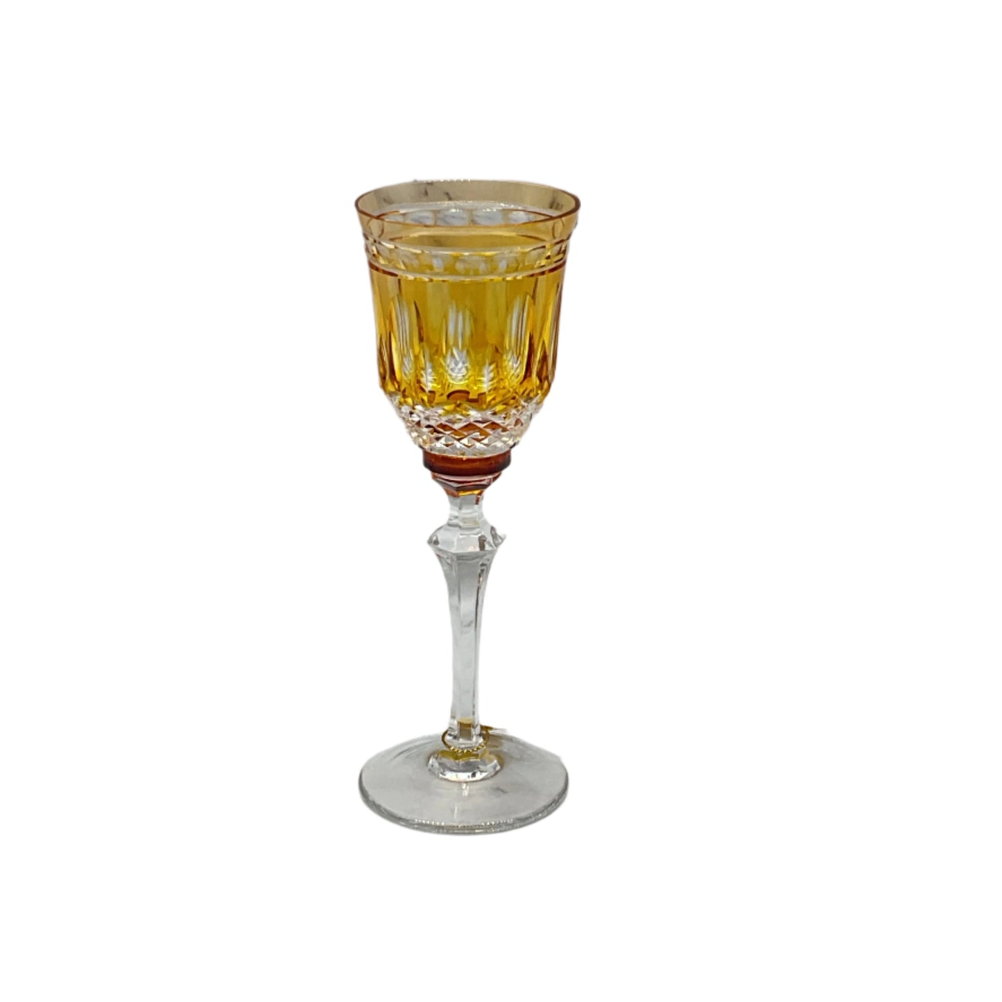 A single amber-colored crystal liquor glass with a clear stem and base, featuring a geometric pattern.