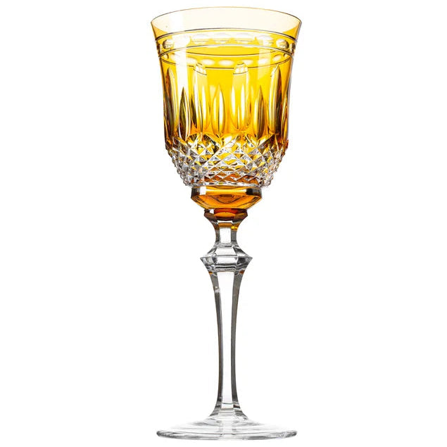 A stemware glass with an amber-colored bowl and clear stem, part of the Serenate Crystal collection.