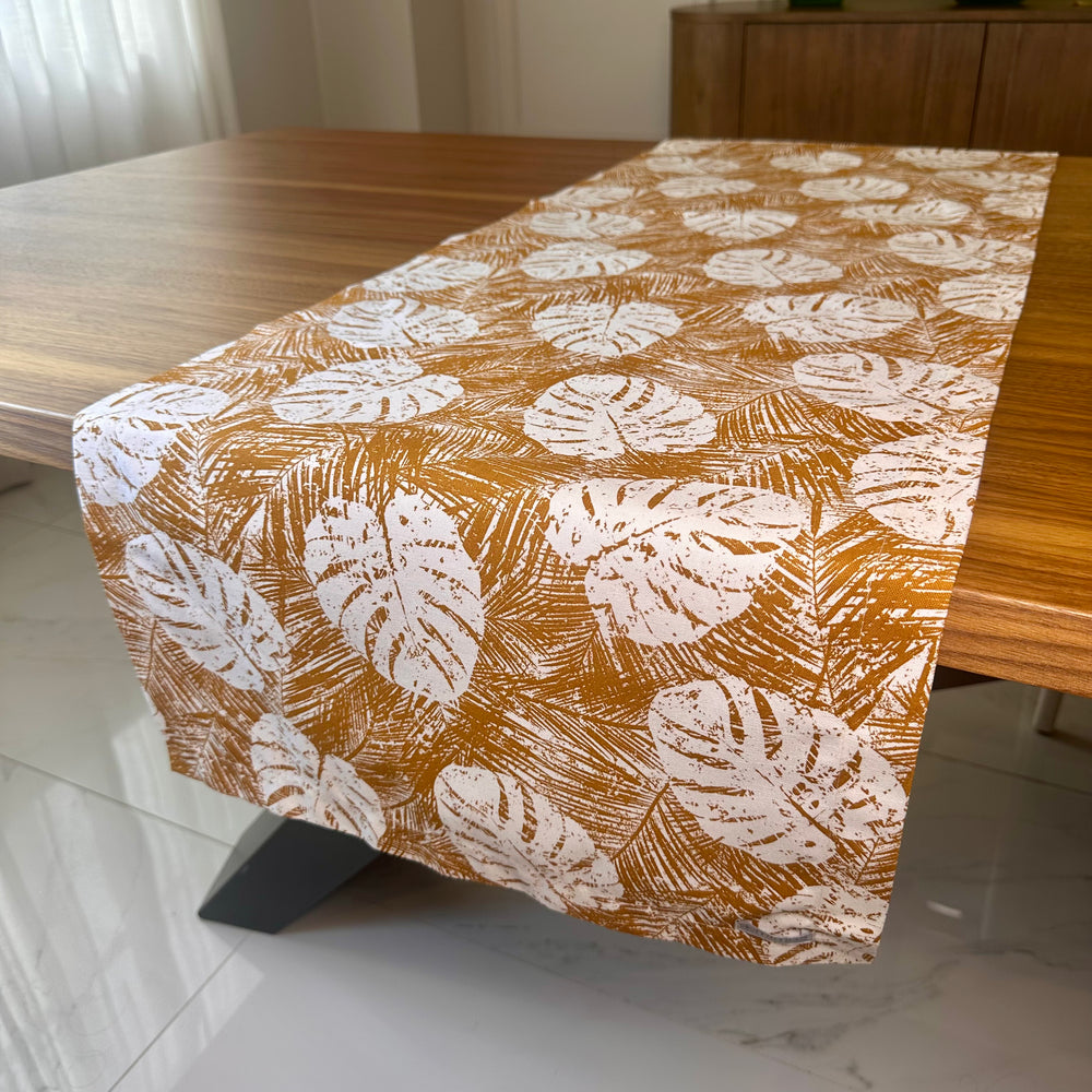 Table runner with leaf pattern on a wooden table