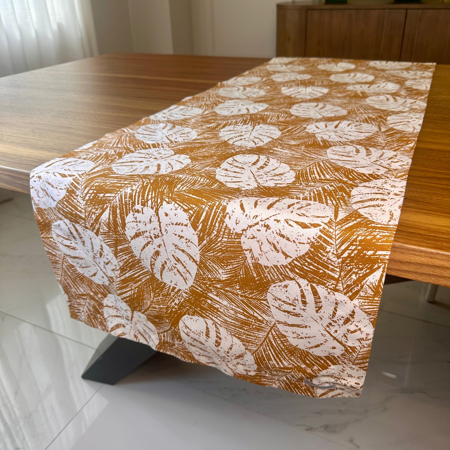 Table runner with leaf pattern on a wooden table