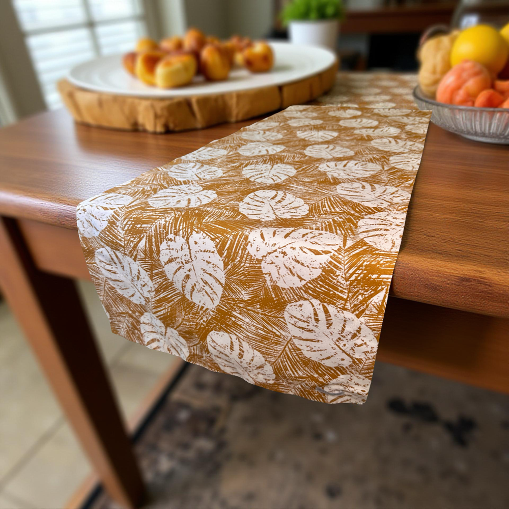 Table runner with leaf pattern on a wooden table
