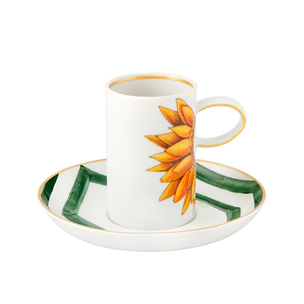 A white coffee cup with a green and orange floral design on the saucer and a prominent orange flower on the side, made by Vista Alegre.