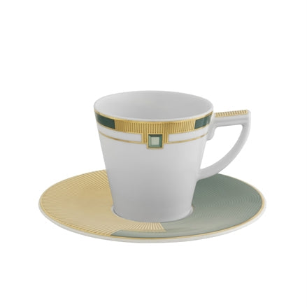 An espresso cup with saucer from the Vista Alegre Emerald Collection, primarily white with gold and green geometric patterns and a precious stone-like detail on the cup's handle.