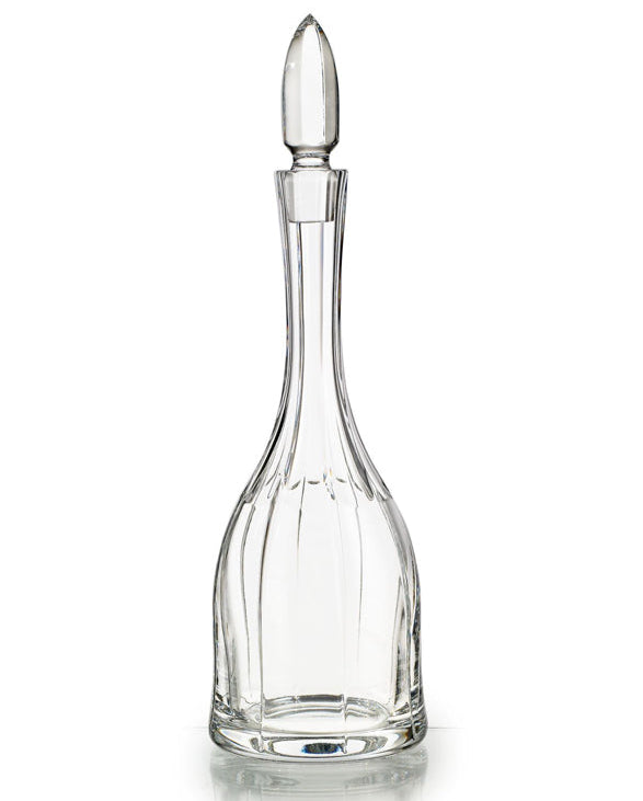 A clear glass wine decanter with a pointed stopper, featuring a detailed floral design.