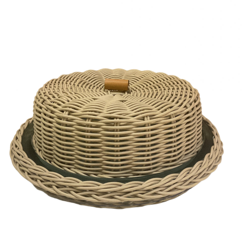 A beige wicker cake dome with a glass base and a wooden handle.